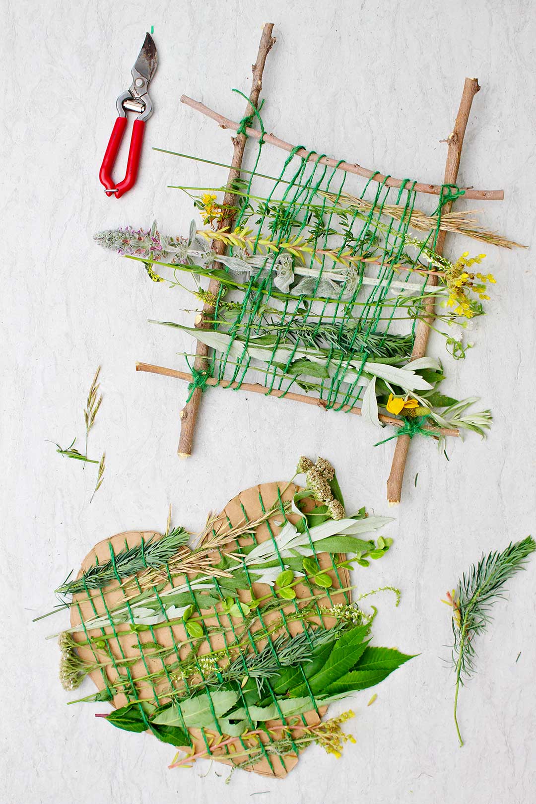 Two completed nature weaving projects. One is done with sticks in a square shape and one is done on a piece of cardboard shaped like a heart.