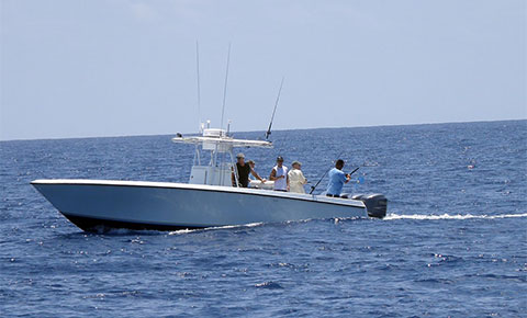 kids and an adult fishing over a pier