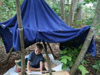 A child sitting under a blue tent

Description automatically generated with low confidence