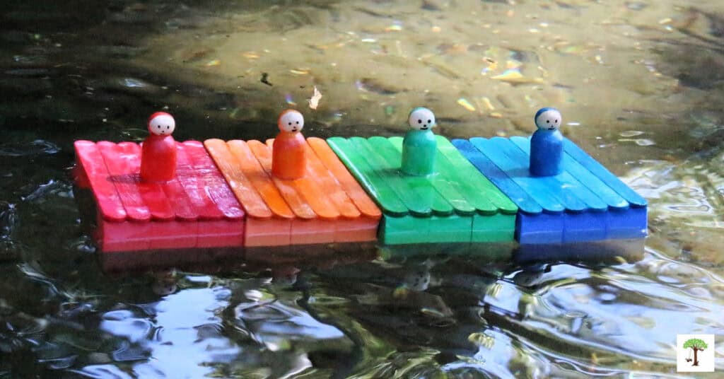 DIY popsicle stick boat toys floating the water at a creek.