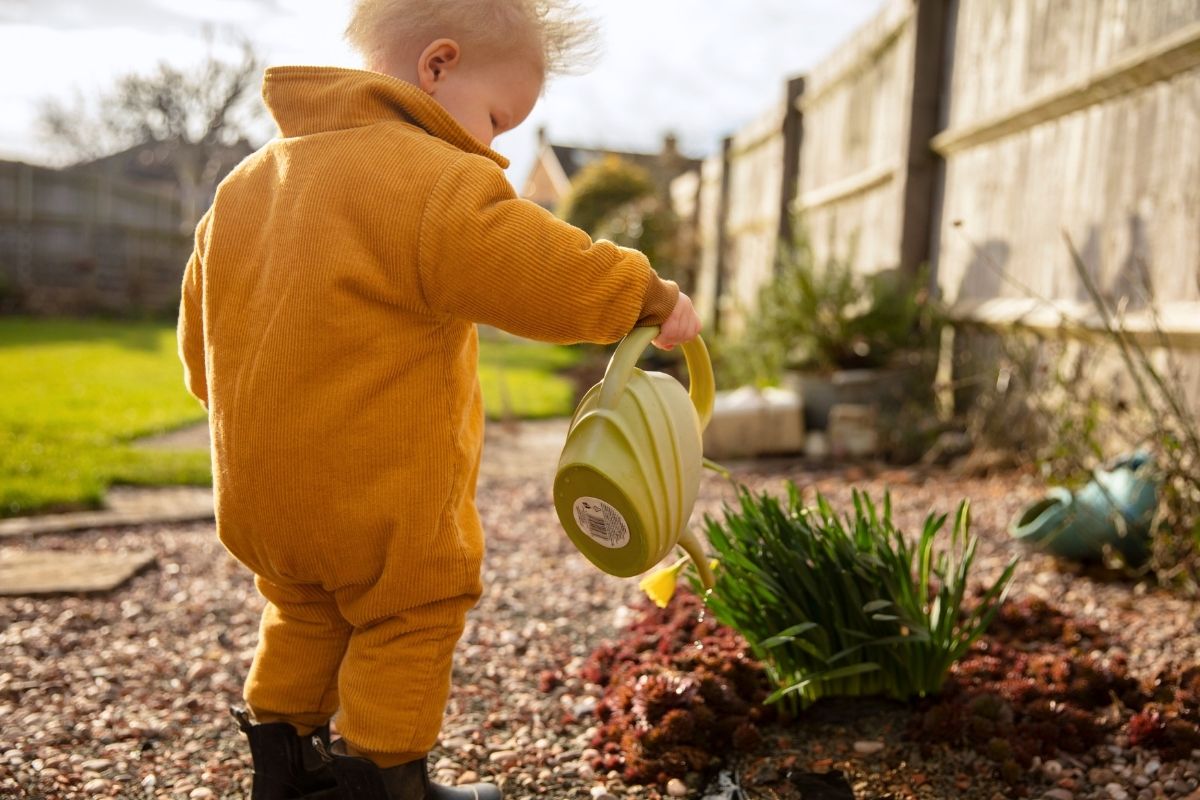 baby watering plants in the garden