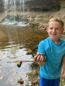 A child holding a fish

Description automatically generated with low confidence