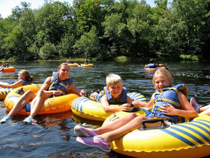 This may contain: some kids are riding on rafts in the water