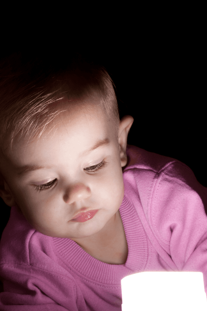 Baby playing with light during sensory play.