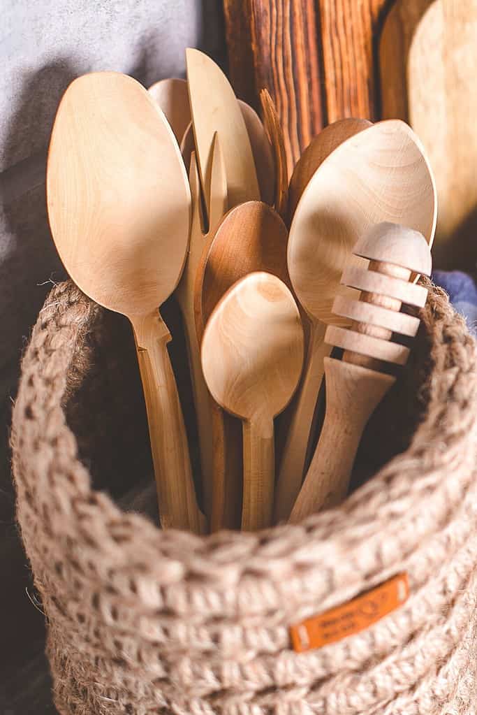 A woven basket holds wooden utensils for toddlers to play with during a sensory learning activity.