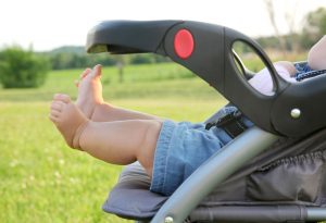 A baby in the stroller in the country side