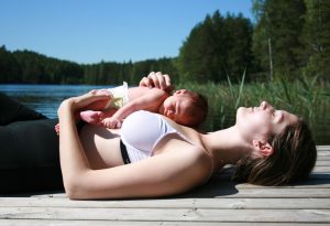 A mother and her newborn child laying in the sun