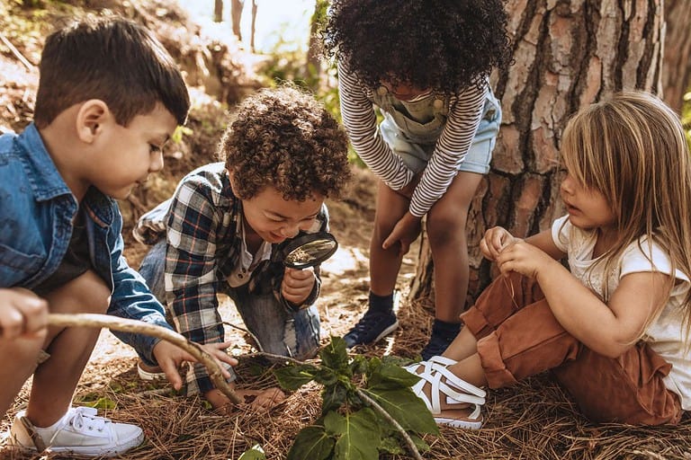 Students participate in an outdoor exploration during a nature-based in an early childhood classroom.