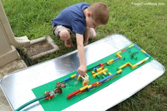 Child playing with a water course built from LEGO bricks (Outdoor Science)