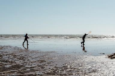 Rock pooling kids and waves and nets